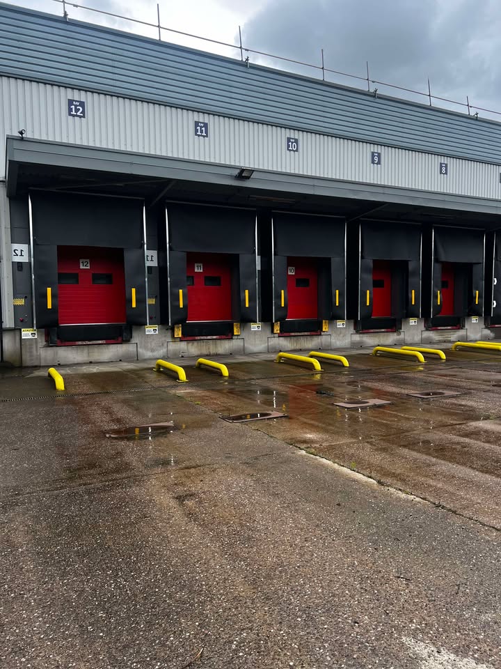 Professional loading bay facility with multiple red sectional doors and dock levelers