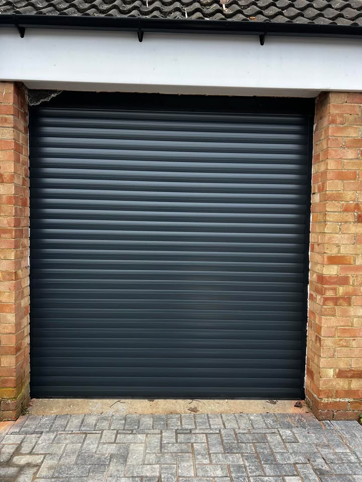 Dark grey garage door with brick pillars