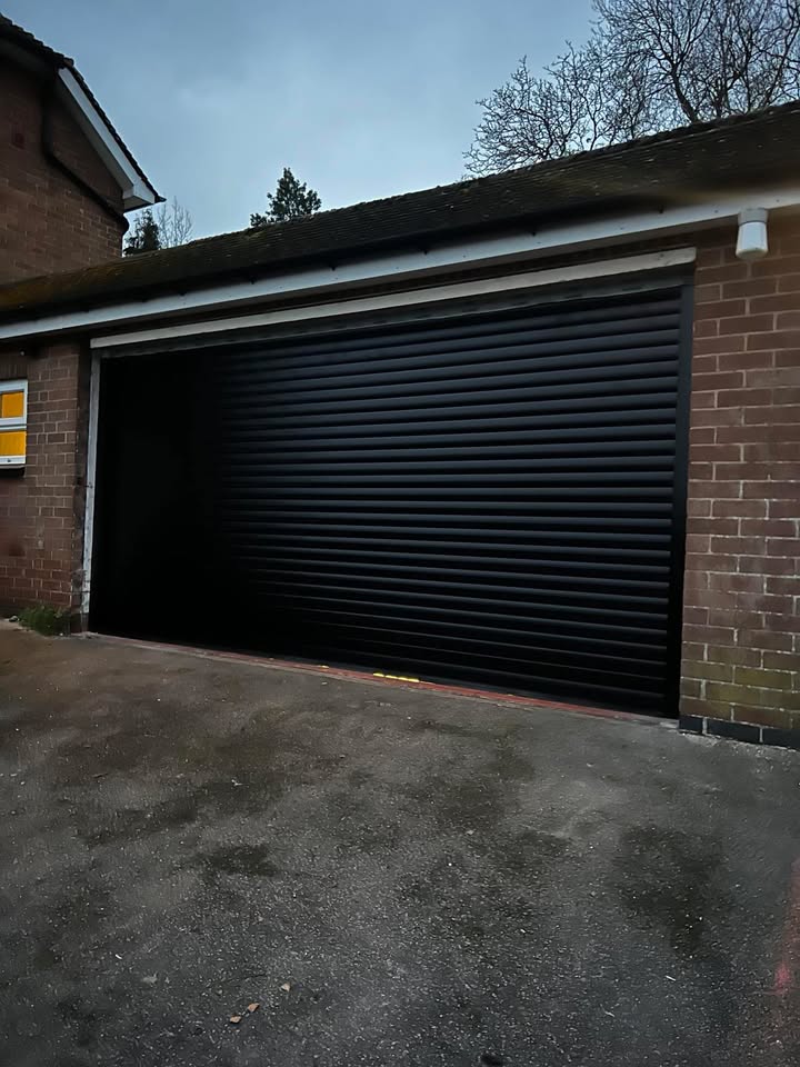 Black roller garage door with brick surround