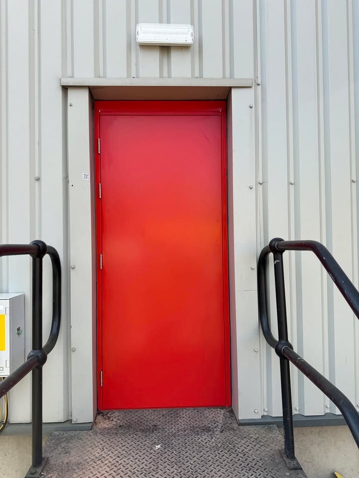 Red steel hinged door with safety railings